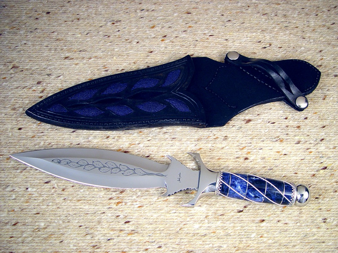 "Amethystine" obverse side view: hand-engraved 440C high chromium stainless steel blade, 304 stainless steel guard and pommel, sterling silver wire wrap and ferrules, Sodalite Gemstone handle, blue Stingray skin inlaid in hand-carved leather sheath
