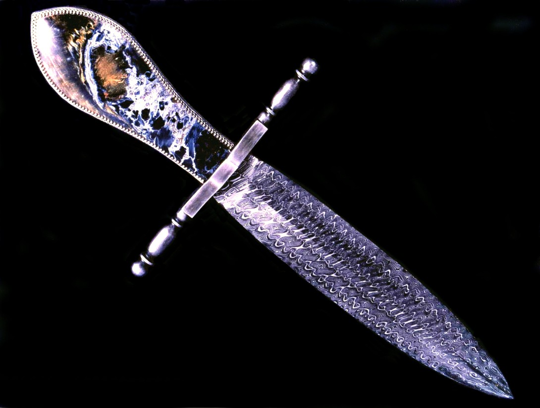 "Conquistador" dagger in twist carbon steel damascus pattern welded blade, antiqued blued steel crossguard, sterling silver bezels and Pietersite Agate gemstone handle