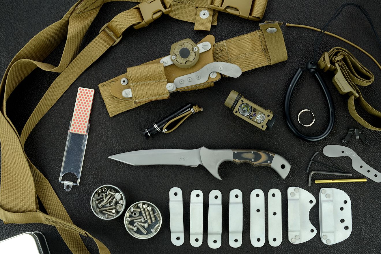 "Korath" tactical combat knife, obverse side view with accessories: tension-locking sheath, Ultimate Belt Loop Extender, sharpener, Lamp independent mount assembly with Maglite solitaire, Streamlight Sidewinder Compact II flashlight, lanyards, hardware, variable mounting straps and clamps, sternum harness, hardware
