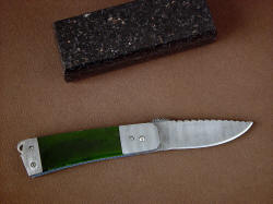"Aries" reverse side view. Twist pattern damascus stainless steel blade, bolsters, and frame with stainless steel screws