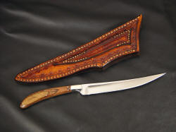 "Boning" custom chef's knife, reverse side view. Sheath is fully tooled even on back side and belt loop, knife has simple and clean grind and finish, sharp geometry