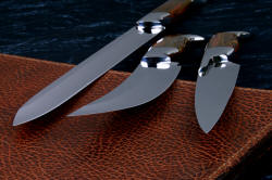 "Bordeaux, Courbe Vaste, Thresher" fine handmade chef's knives, BBQ knives, blade points and cutting edges detail in T3 cyrogenically treated 440C high chromium stainless steel blades, 304 stainless steel bolsters, Caprock petrified wood gemstone handles, Bison (American Buffalo), leather shoulder book case