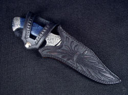 "Domovoi" sheathed view. Black sheath with brown highlights is hand-carved, hand tooled, with a more traditional style