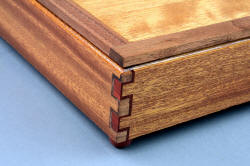 "Kadi" hardwood case, joinery detail. Double-double box joints in lauan, black walnut, redheart hardwood. Feet are turned redheart hardwood.