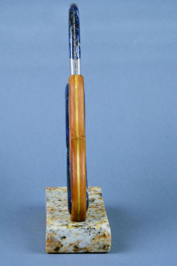 "Sanchez" fine custom handmade chef's knife, front view showing the raised domes of polished sodalite gemstone, and the bit of green poplar in the slip spacer