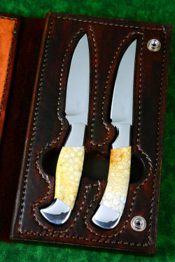 "Steak Knives" in leather book-case storage. Finger holes around handles allow easy removal of knives from case