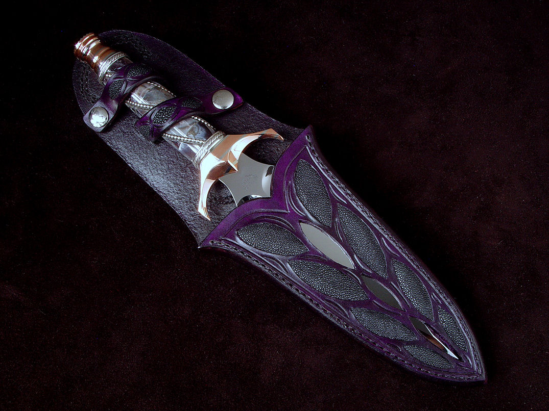 "Amethistine" dagger, obverse side view in 440C high chromium stainless steel blade, diffusion welded copper, nickel silver fittings, sterling silver gallery wire wrap and accents, Amethyst crystal gemstone pommel, hand-carved leather sheath inlaid with black rayskin