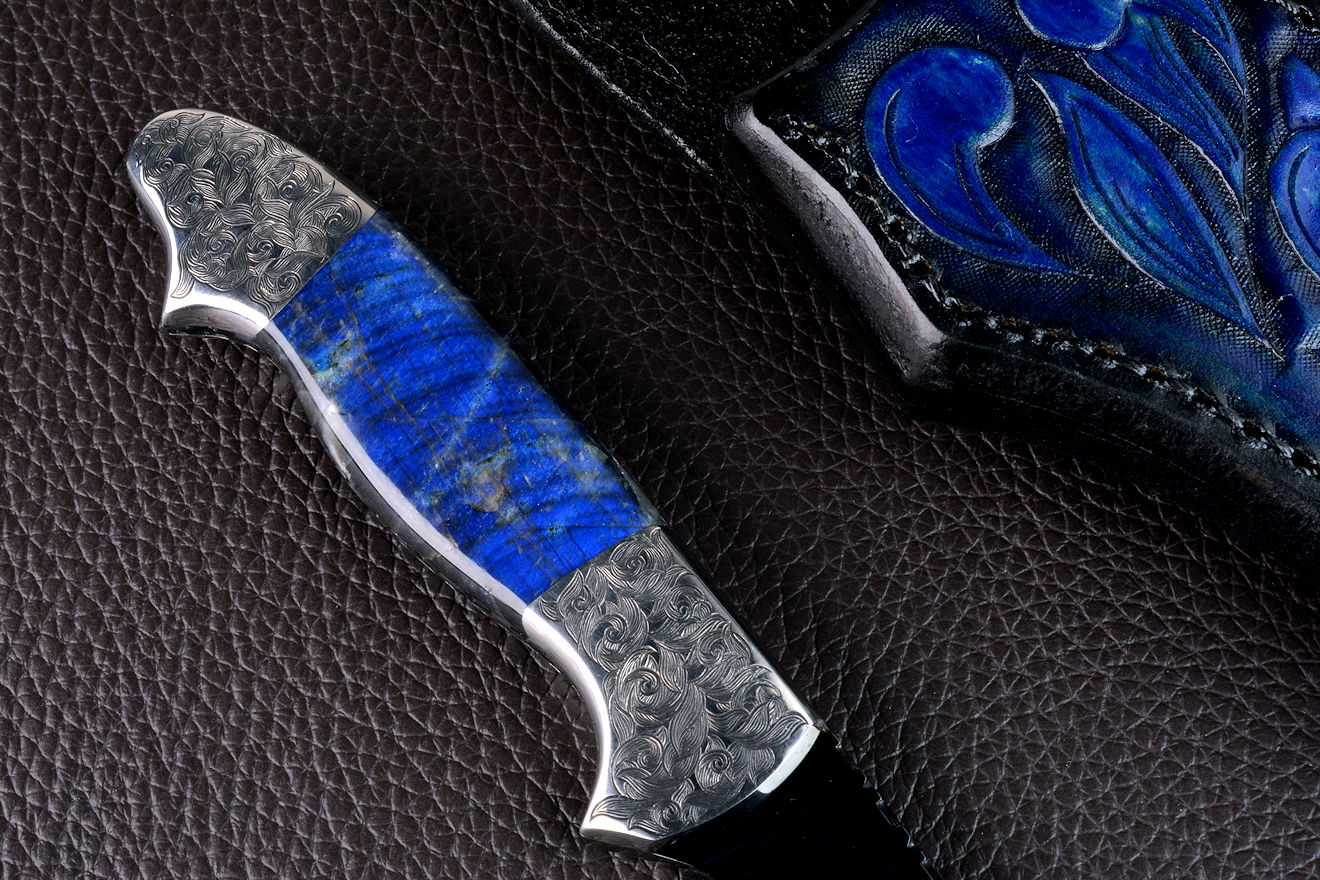"Carina" in mirror polished and hot-blued O1 high carbon tungsten-vanadium tool steel blade, hand-engraved 304 stainless steel bolsters, Labradorite gemstone handle, hand-carved, hand-dyed leather sheath