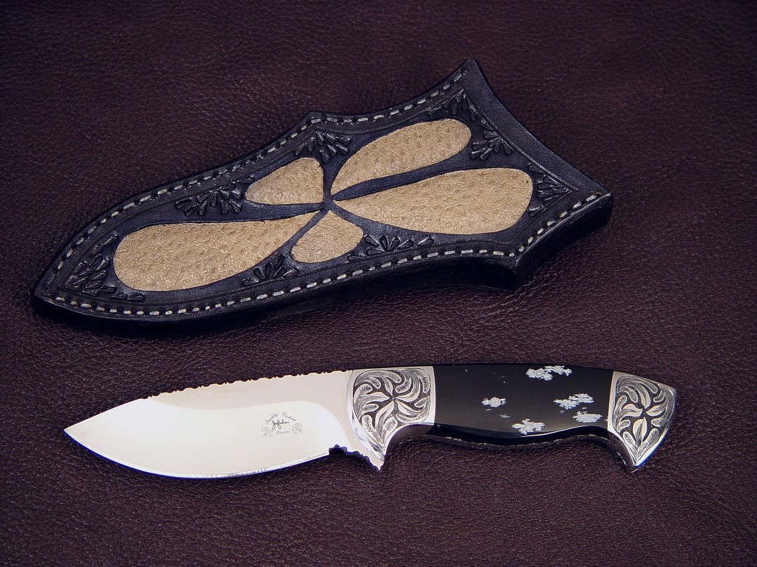 "Chama" obverse side view in 440C high chromium stainless steel blade, hand-engraved low carbon steel bolsters, snowflake obsidian gemstone handle, emu skin inlaid in hand-carved leather sheath
