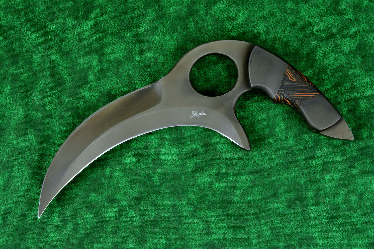 "Drepan" tactical karambit knife, obverse side view in T4 cryogenically treated 440C high chromium martensitic stainless steel blade, 304 stainles steel bolsters, orange/black G10 fiberglass epoxy composite laminate, sheath in leather shoulder, hand-tooled, nylon stitching, stainless steel reinforcement