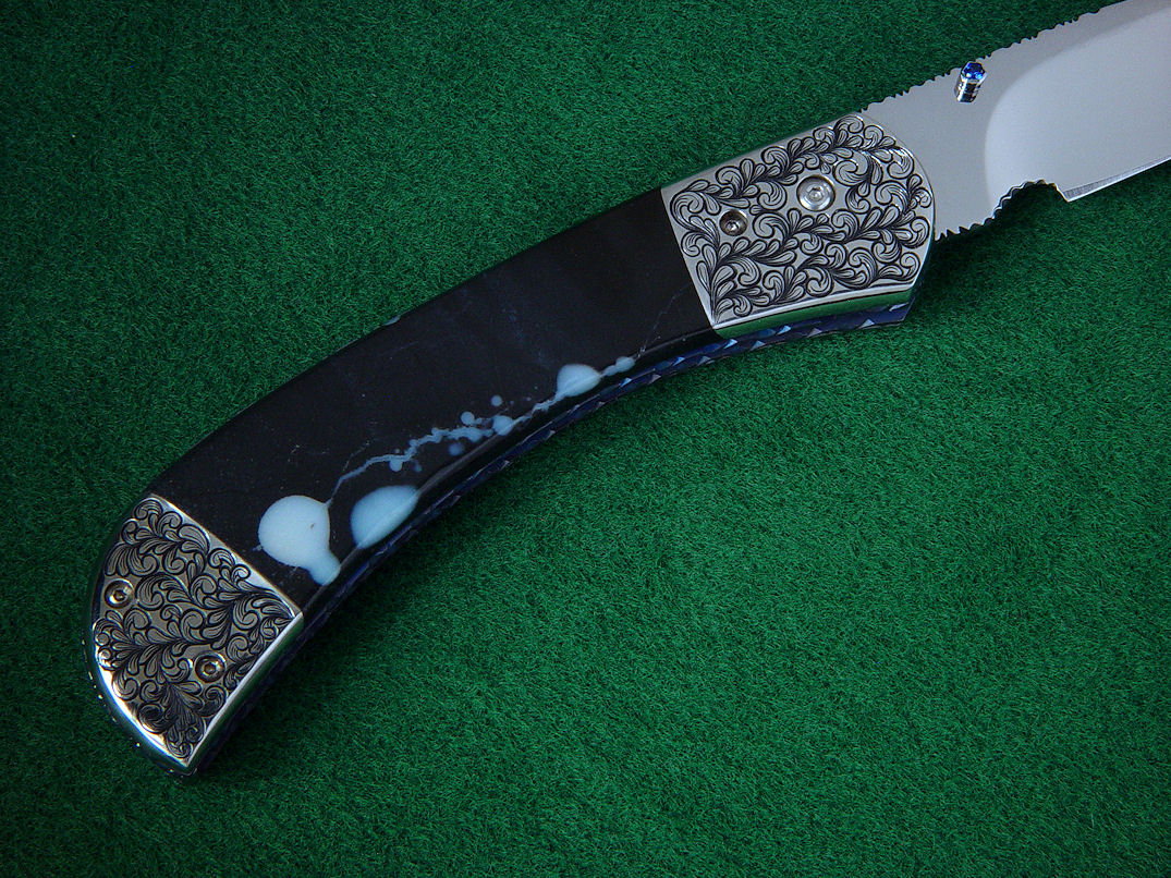 "Gemini" Liner Lock Folding Knife, reverse side view in 440C high chromium stainless steel blade, hand-engraved 304 stainless steel bolsters, anodized titanium liners, sapphire set thumb studs, case of Black Galaxy Granite gabbric anorothosite
