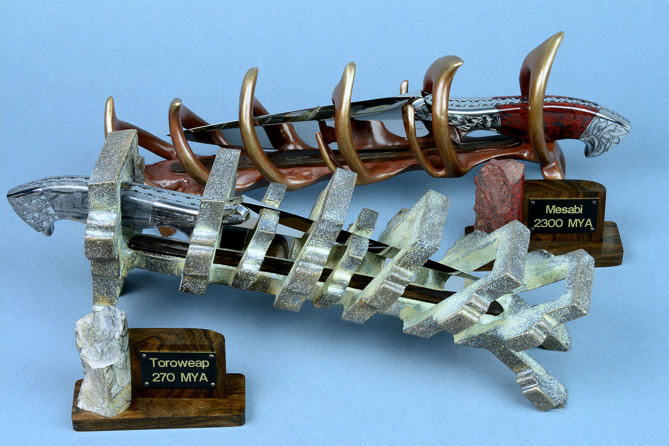 "Mesabi" and "Toroweap" custom knife sculpture in 440C high chromium martensitic stainless steel blades, hand-engraved 304 stainless steel bolsters, Picasso Marble gemstone and Fossil Stromatolite gemstone handles, stands in cast bronze and ziricote hardwood, brass