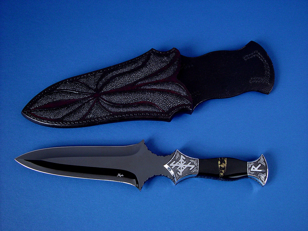 "Vesta" Dagger, obverse side view in hot-blued O1 high carbon tungsten-vanadium tool steel blade, hand-engraved 304 stainless steel bolsters, Australian Black Jade and Apache Gold (chrysopyrite and slate) gemstone handle, hand-carved leather sheath inlaid with stingray skin