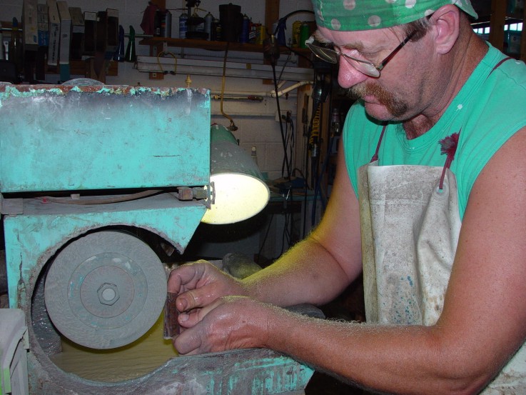 Roughing in gemstone handle material on the lapidary wet grinder