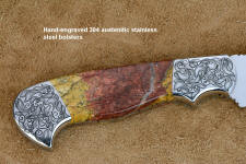 "Aldebaran" obverse side bolster engraving detail in CPM154CM high molybdenum powder metal technology stainless steel blade, hand-engraved 304 stainless steel bolsters, Sunset Jasper gemstone  handle, hand-carved leather sheath inlaid with ostrich leg skin