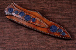 "Andromeda" sheath back view in T3 deep cryogenically treated CPM 154CM powder metal technology high molybdenum stainless steel blade, 304 stainless steel bolsters, K2 Azurite Granite gemstone handle, hand-carved leather sheath inlaid with blue rayskin