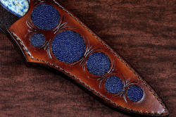 "Andromeda" sheath front detail view in T3 deep cryogenically treated CPM 154CM powder metal technology high molybdenum stainless steel blade, 304 stainless steel bolsters, K2 Azurite Granite gemstone handle, hand-carved leather sheath inlaid with blue rayskin