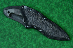"Ari B'Lilah" Counterterrorism Tactical Knife, leather sheathed detail, front side, in T3 cryogenically treated CPM 154CM powder metal technology high molybdenum martensitic stainless steel blade, 304 stainless steel bolsters, Black/Red G10 fiberglass/epoxy composite handle, hybrid tension tab-locking sheath in kydex, anodized aluminum, stainless steel, titanium