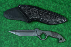 "Ari B'Lilah" Counterterrorism Tactical Knife, obverse view with leather sheath front, in T3 cryogenically treated CPM 154CM powder metal technology high molybdenum martensitic stainless steel blade, 304 stainless steel bolsters, Black/Red G10 fiberglass/epoxy composite handle, hybrid tension tab-locking sheath in kydex, anodized aluminum, stainless steel, titanium