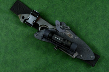 "Ari B'Lilah" counterterrorism, tactical, combat knife, sheathed view with HULA and UBLX accessories in T4 cryogenically treated 440C high chromium martensitic stainless steel blade, 304 stainless steel bolsters, red/black  G10 handle, hybrid tension tab locking sheath in kydex, anodized aluminum, anodized titanium, black oxide stainless steel