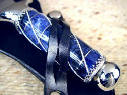 "Amethystinel" dagger handle detail in sheath. Retention strap with windows around wire wrapped gemstone knife handle. 