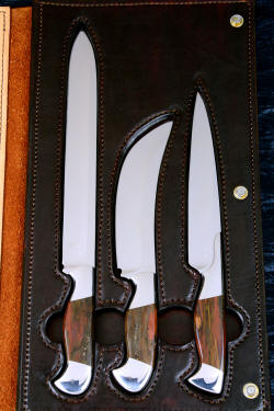 "Bordeaux, Courbe Vaste, Thresher" fine handmade chef's knives, BBQ knives, book case interior view in T3 cyrogenically treated 440C high chromium stainless steel blades, 304 stainless steel bolsters, Caprock petrified wood gemstone handles, Bison (American Buffalo), leather shoulder book case