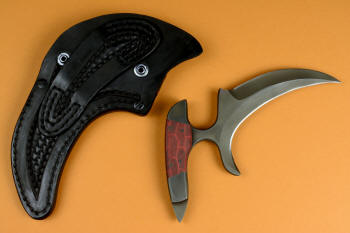 "Chela" karambit knife, reverse side view in T4 cryogenically treated 440C high chromium martensitic stainless steel blade, 304 stainless steel bolsters, red and black tortoiseshell G10 composite handle, leather sheath with stainless steel and nylon