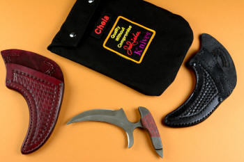 "Chela" karambit knife, obverse side view in T4 cryogenically treated 440C high chromium martensitic stainless steel blade, 304 stainless steel bolsters, red and black tortoiseshell G10 composite handle, leather sheath with stainless steel and nylon, envelope bag in 1000 denier nylon Cordura, polyester felt lining, stainless steel snaps, embroidered with removable name patch