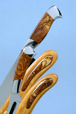 "Concordia and Talitha" fine handmade chef's knives, Deschutes Jasper inlay and gemstone detail, in stand view, in T3 cryogenically treated CPM154CM high molybdenum powder metal technology stainless steel blades, 304 stainless steel bolsters, Deschutes Jasper gemstone handles, stand of cherry hardwood, Deschutes Jasper gemstone, Delicatus Gold Granite