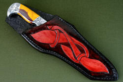 "Knapp Trailhead" sheathed view. Sheath is deep yet displays bold handle, engraving is repeated in hand-carved, hand-dyed leather