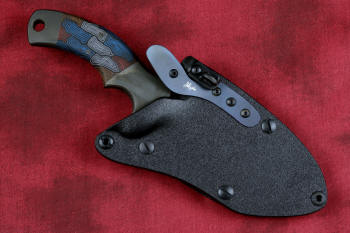 "Krag" tactical, counterterrorism, crossover knife, sheathed view in ATS-34 high molybdenum martensitic stainless steel blade, 304 stainless steel bolsters, multicolored tortoiseshell  G10 fiberglass/epoxy composite handle, hybrid tension tab-locking sheath in kydex, anodized aluminum, black oxide stainless steel and anodized titanium