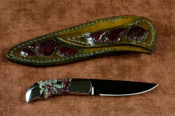 "Lacerta" reverse side view (without reflector above), in deep cryogenically treated O1 tungsten-vanadium tool steel blade, hot blued, 304 stainless steel bolsters, Eudialite gemstone handle, sheath of hand-carved leather inlaid with Ostrich leg skin