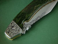 "Procyon" liner lock folding knife, obverse side view,in hand-engraved ATS-34 high molybdenum stainless steel blade, hand-engraved 304 stainless steel bolsters, anodized 6AL4V titanium liners and lockplate, Pounamu New Zealand Greenstone Nephrite Jade gemstone handle, case of Granite, Quartz Terrazzo composite