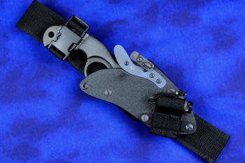 "Skeg"  tactical, counterterrorism, crossover knife, sheathed view with LIMA accessory in T4 Cryogenically treated ATS-34 high molybdenum martensitic stainless steel blade, 304 stainless steel bolsters, white and black tortoiseshell pattern G10 fiberglass/epoxy composite handle, hybrid tension tab-locking sheath in kydex, anodized aluminum, black oxide stainless steel and anodized titanium