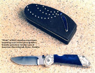 "Pinon" folding knife, back lock mechanism in 440C high chromium stainless steel blade, engraved nickel silver bolsters, sodalite gemstone handle, walnut case with brass pique work and sodalite accents