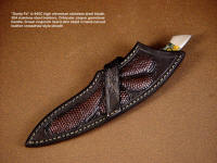 "Santa Fe" in crossdraw style sheath, worn at an angle on the belt. Sheath is brown lizard skin inlaid in hand-carved leather